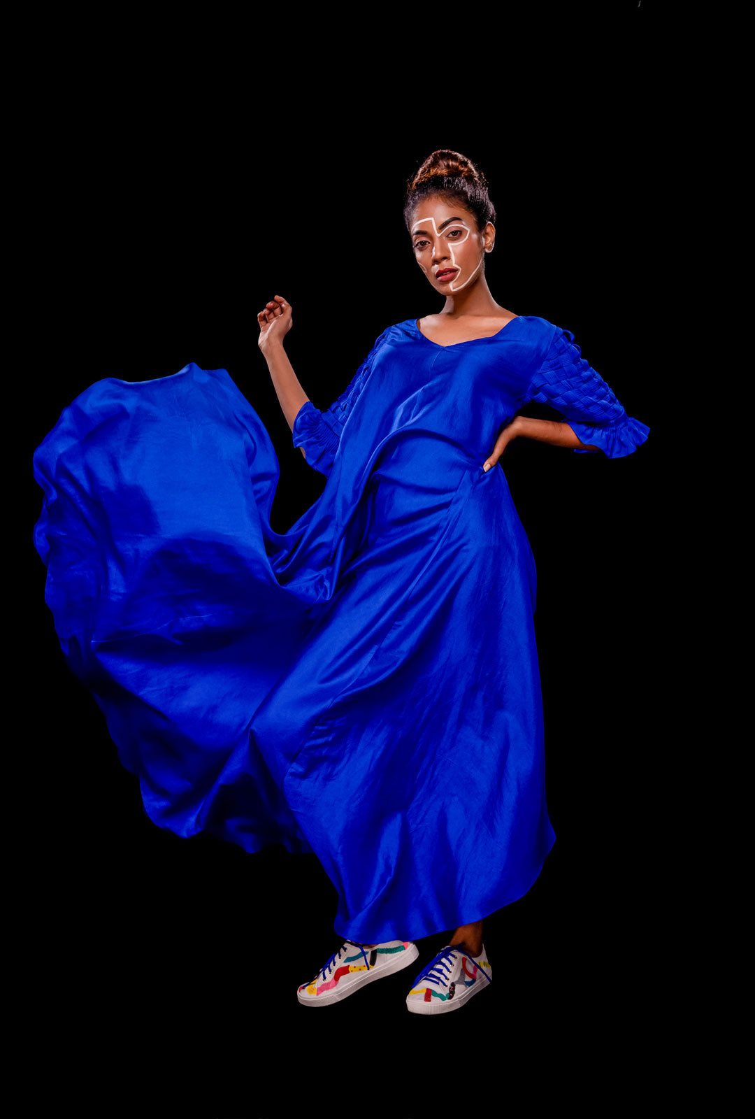 Front view of a blue asymmetrical gown with pintuck basket weave sleeve.
