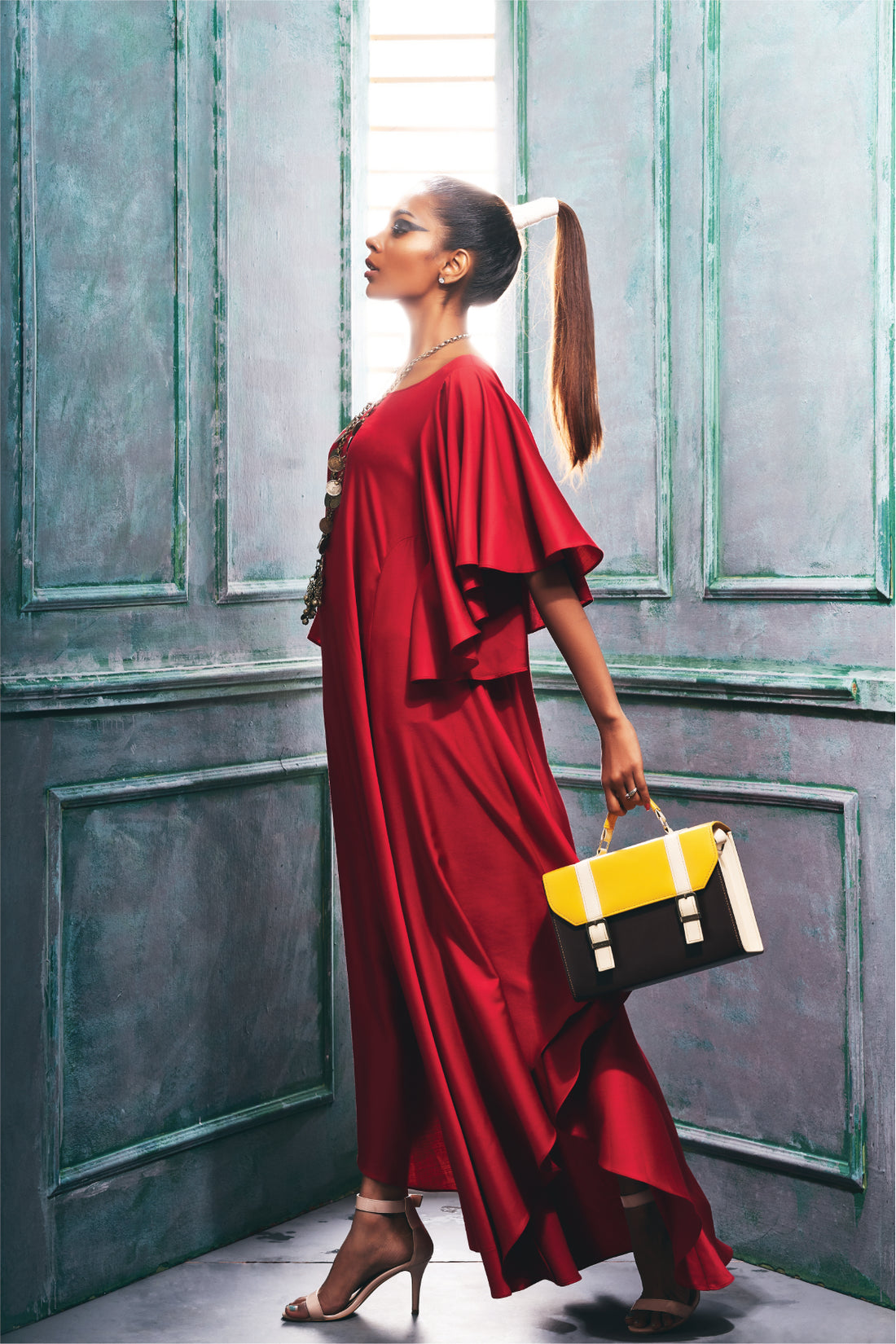 Side view of a maroon dress with asymmetrical hemline cascade sleeve.