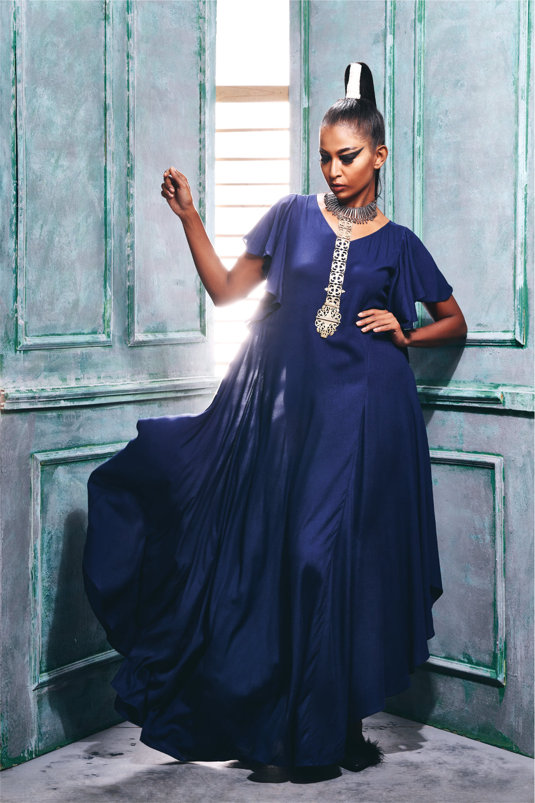 Front view of the midnight blue dress with hemline cascade sleeve.