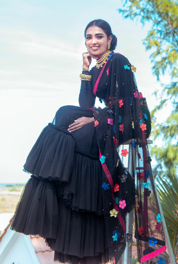 The complete view of the Black Tulle Ruffle Half And Half Saree worn by a model.